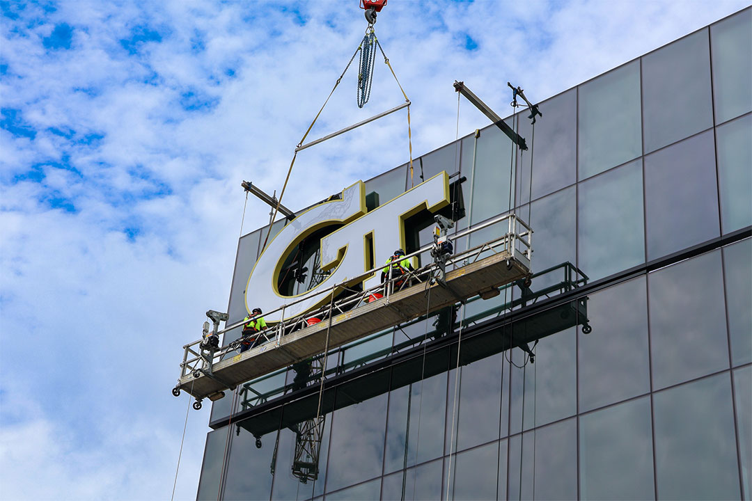 GT signage being hoisted onto a building