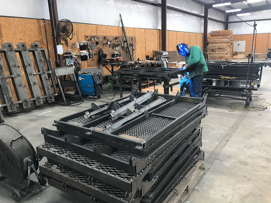 A welder working on some large pieces of metal in a workshop