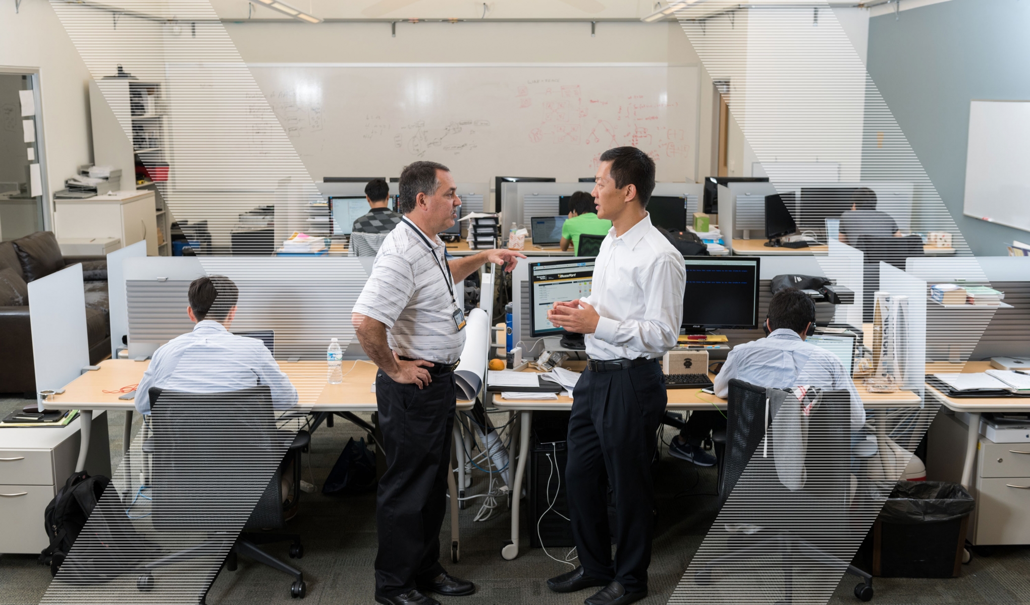 Bo Rotoloni and Wenke Lee discuss cyber security in a busy office