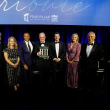 A group of people stand on stage during the 2025 Four Pillar Tribute Award ceremony